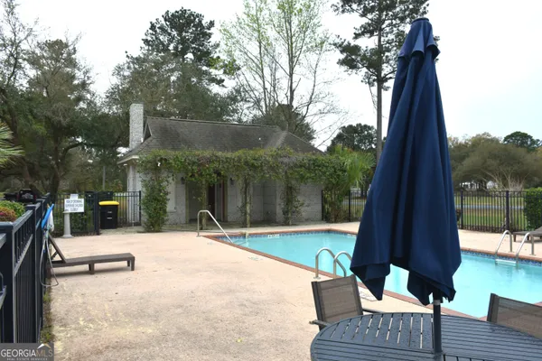 a view of a patio with a table chairs and a backyard