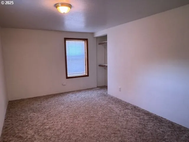 an empty room with windows and closet