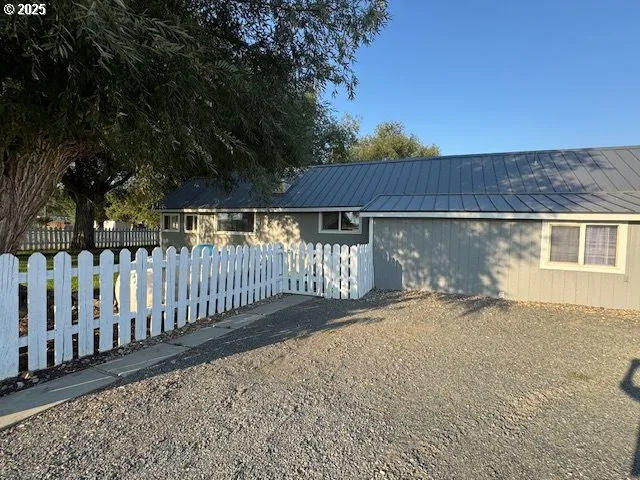 a view of a small yard in front of a house with wooden fence