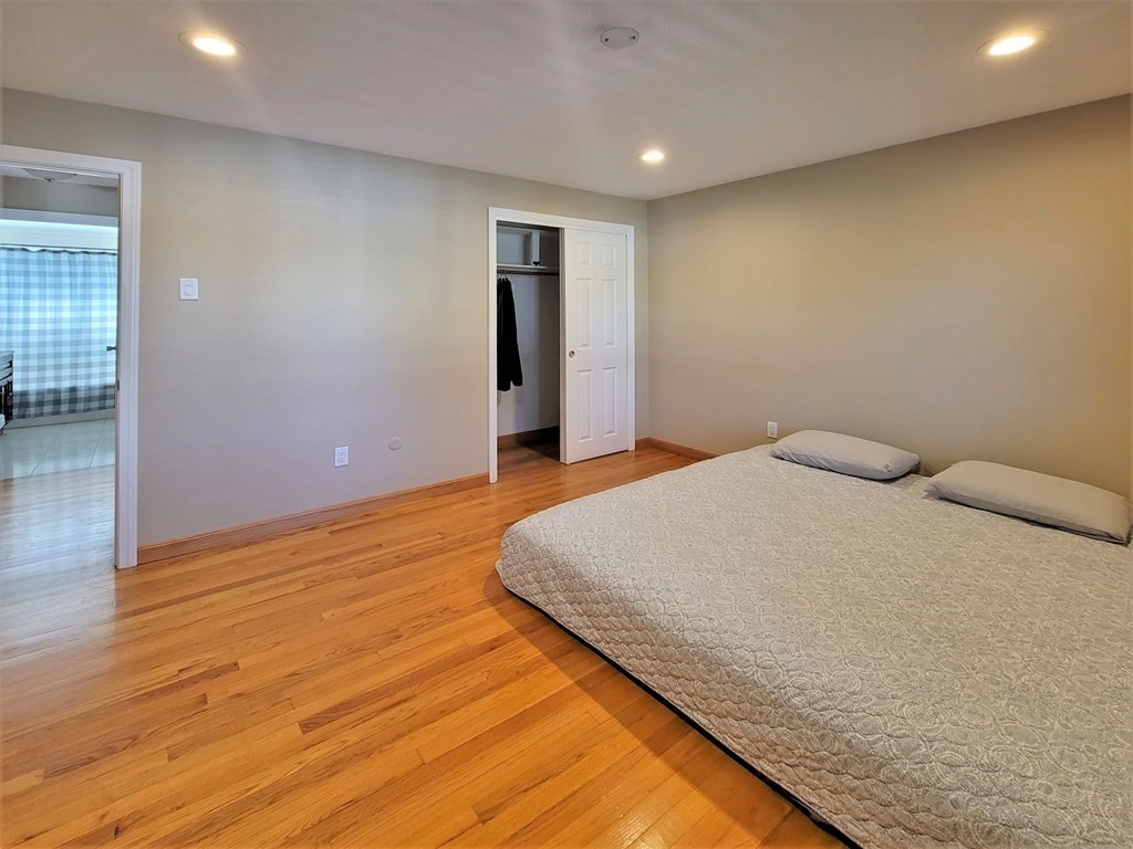 38 Will Drive, Unit 42 Canton, MA 02021 - Photo 16 of 25 a bedroom with a bed and wooden floor