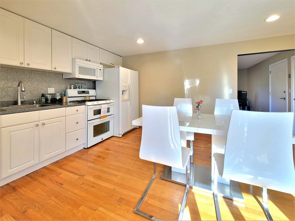 38 Will Drive, Unit 42 Canton, MA 02021 - Photo 9 of 25 a large kitchen with stainless steel appliances granite countertop a stove a sink a white table and chairs