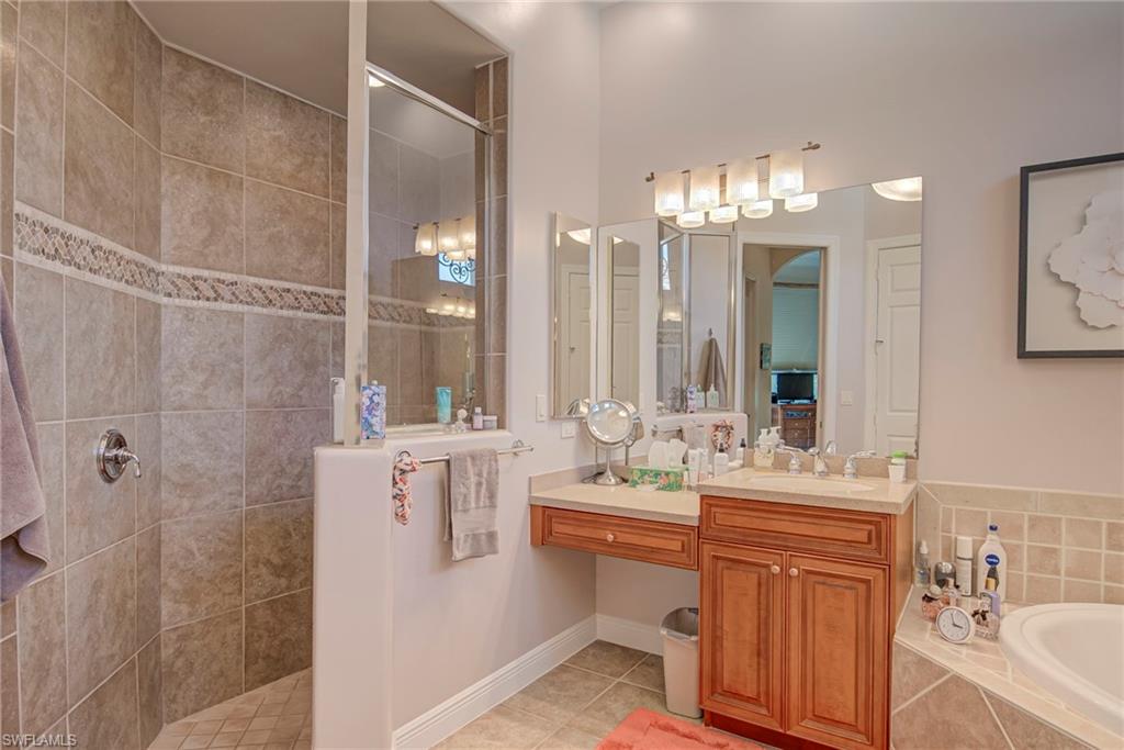 3126 Terramar Court Naples, FL 34119 - Photo 18 of 31 a bathroom with double vanity sinks a toilet a mirror and shower