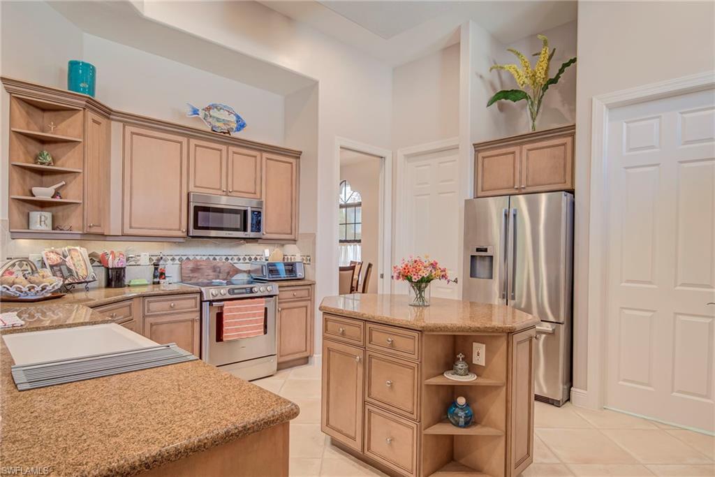 3126 Terramar Court Naples, FL 34119 - Photo 10 of 31 a kitchen with stainless steel appliances granite countertop a refrigerator sink and stove