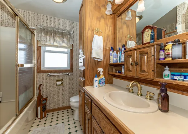 a bathroom with a sink a toilet and shower