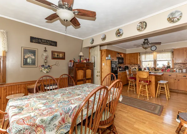 a dining hall with stainless steel appliances granite countertop a dining table and chairs with wooden floor