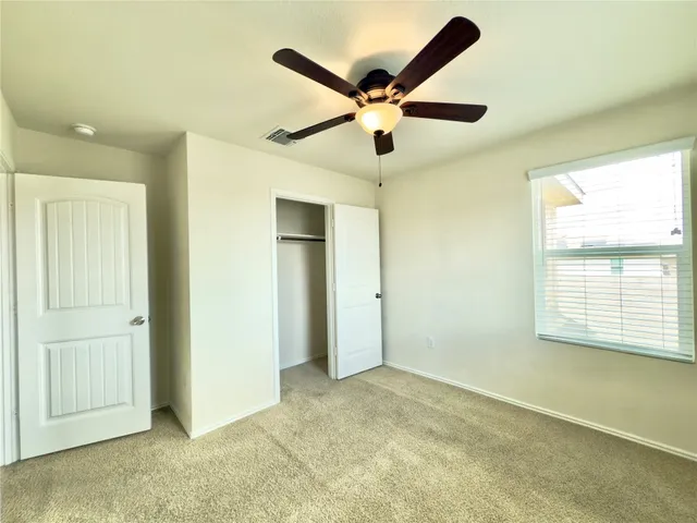 a view of a livingroom with a ceiling fan and window