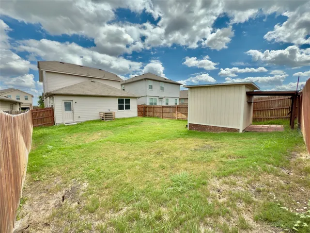a view of a house with a big yard and large tree