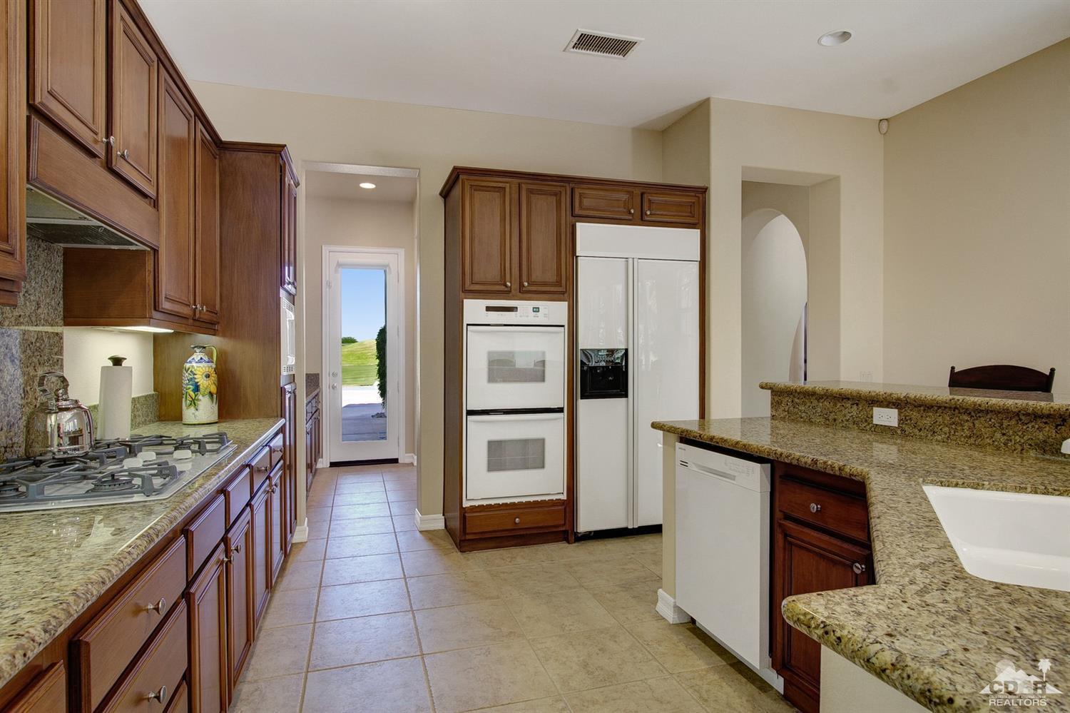 388 Loch Lomond Road Rancho Mirage, CA 92270 - Photo 17 of 41 a kitchen with stainless steel appliances granite countertop a sink stove and refrigerator