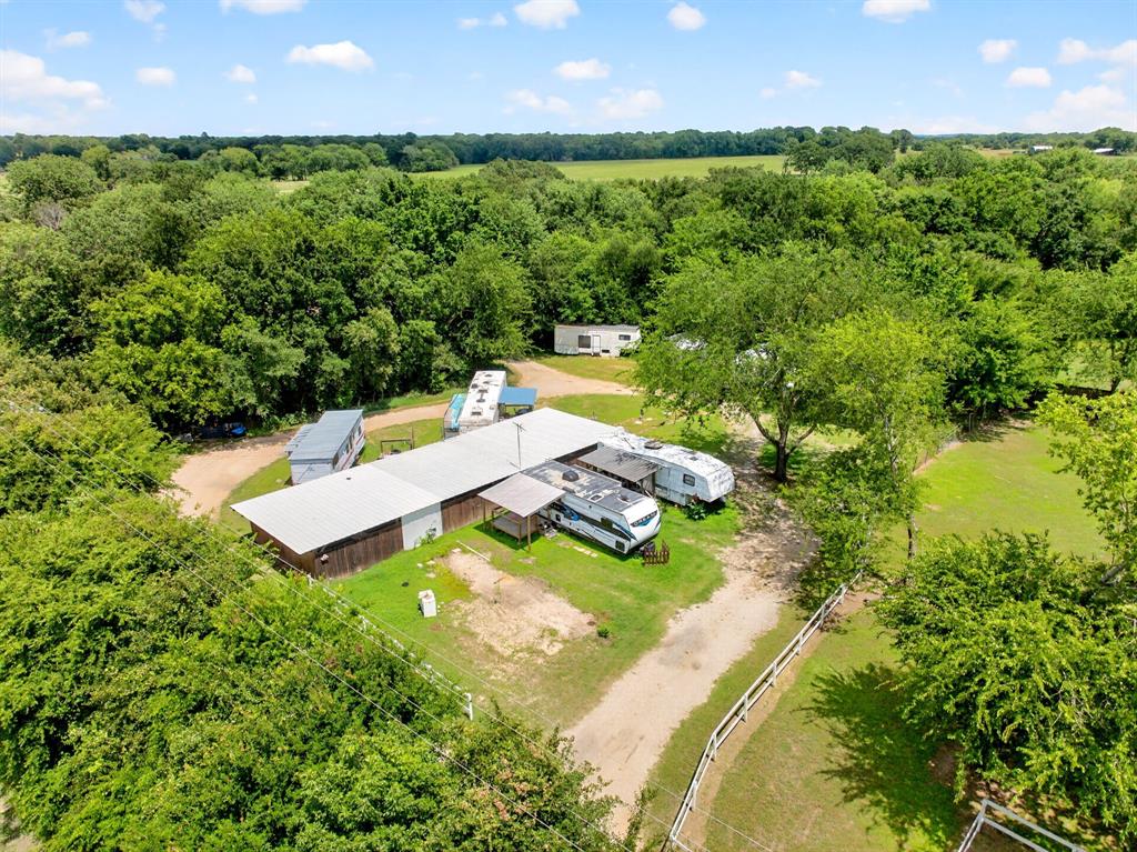 111 County Road 2806 Mabank, TX 75147 - Photo 32 of 34 Expansive rural property featuring a large outbuilding with a metal roof, gravel driveways, and open grassy areas