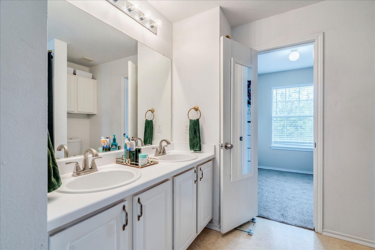 148 Buttercup Way Kyle, TX 78640 - Photo 15 of 33 Full bathroom featuring double vanity and light colored carpet