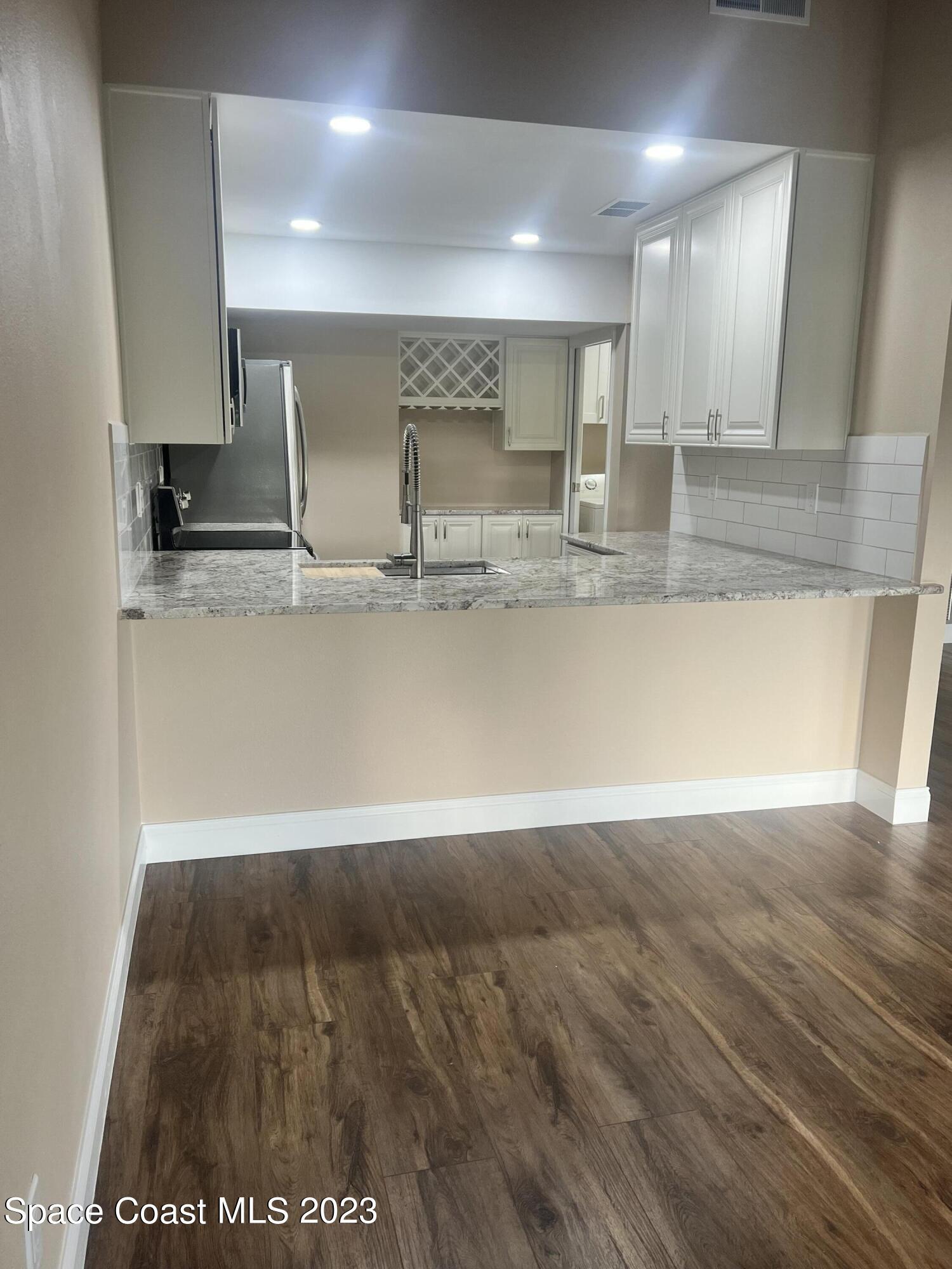 161 Augusta Way Melbourne, FL 32940 - Photo 13 of 26 a view of a kitchen with stainless steel appliances wooden floor