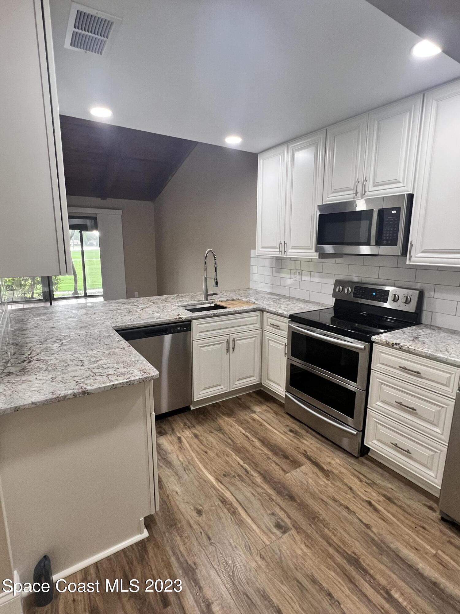 161 Augusta Way Melbourne, FL 32940 - Photo 14 of 26 a kitchen with stainless steel appliances granite countertop a stove a sink and a microwave