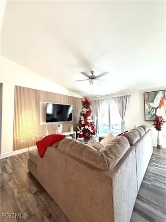 a living room with furniture a flat screen tv and a large window