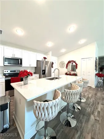 a kitchen with stainless steel appliances kitchen island granite countertop a sink and a refrigerator
