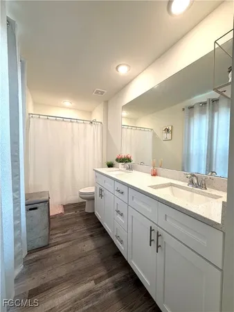 a spacious bathroom with a double vanity sink a mirror and a shower