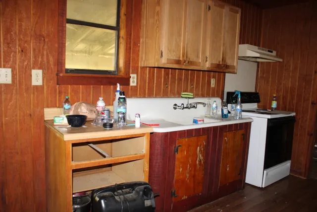 a kitchen with granite countertop wooden cabinets a sink and a stove