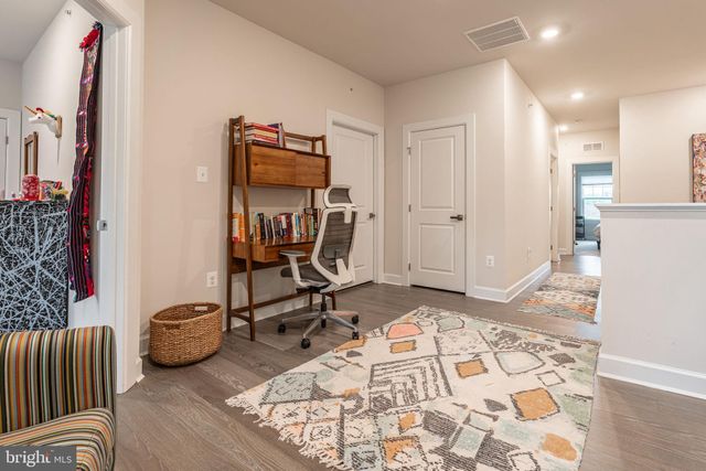 a view of a hallway with workspace and a couch