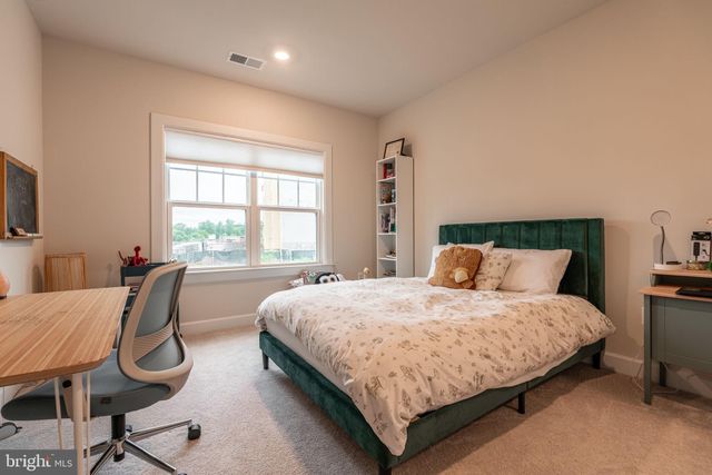 a bedroom with a bed chair and a window