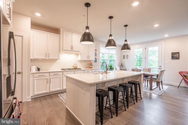 a kitchen with stainless steel appliances kitchen island granite countertop a stove a sink a center island and cabinets