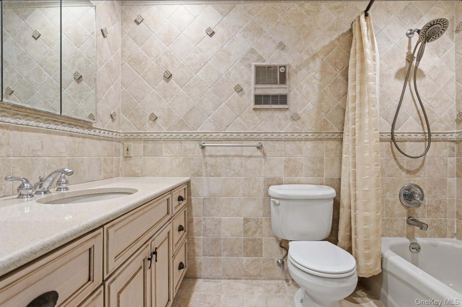 253 Dune Road, Unit 49 Westhampton Beach, NY 11978 - Photo 12 of 31 a bathroom with a granite countertop sink a toilet and a bathtub