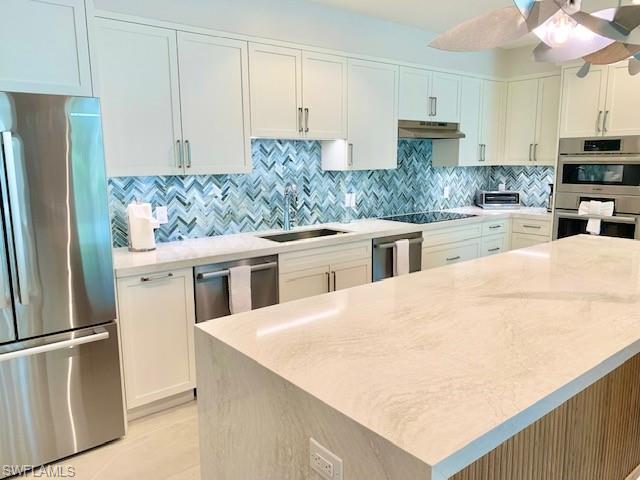 6573 Marissa Loop, Unit 2005 Naples, FL 34108 - Photo 31 of 34 a kitchen with stainless steel appliances a refrigerator sink and cabinets