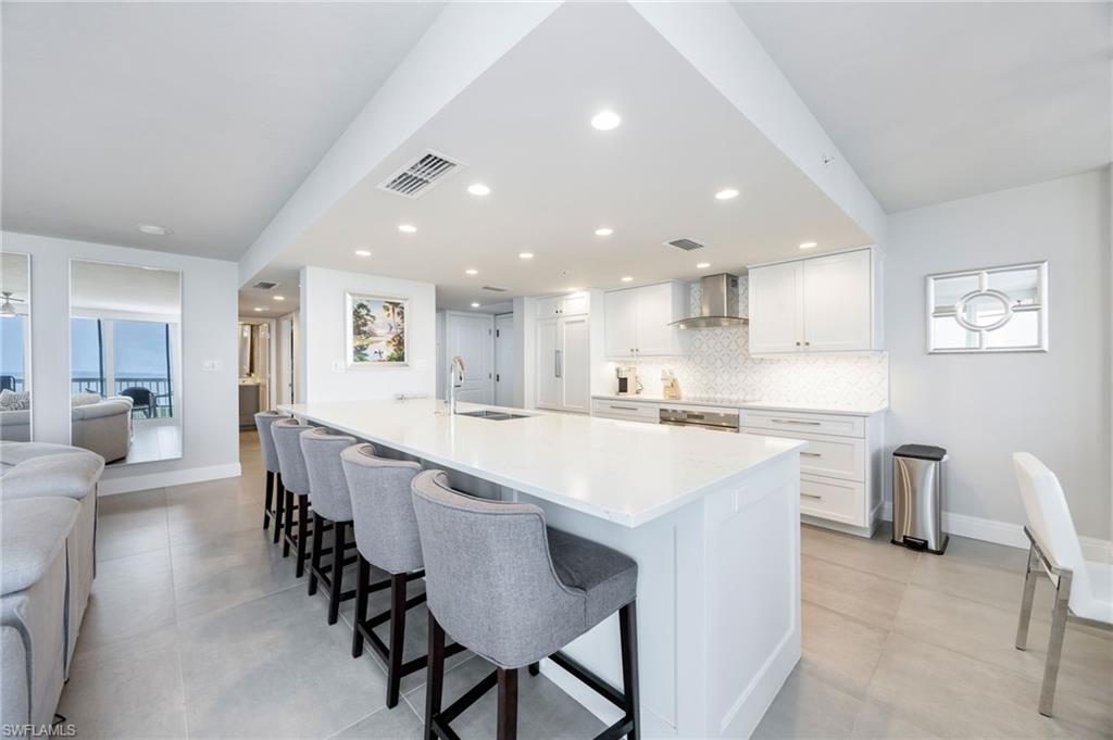 6573 Marissa Loop, Unit 2005 Naples, FL 34108 - Photo 5 of 25 a large white kitchen with a table and chairs