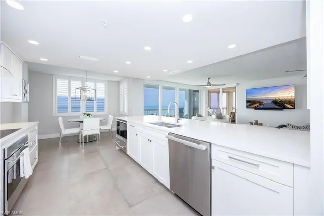 a large white kitchen with a large window