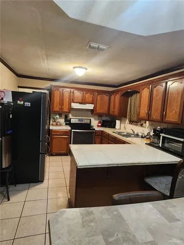 a large kitchen with stainless steel appliances a stove a table and chairs