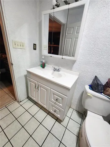 a bedroom with a bed and a lamp on dresser