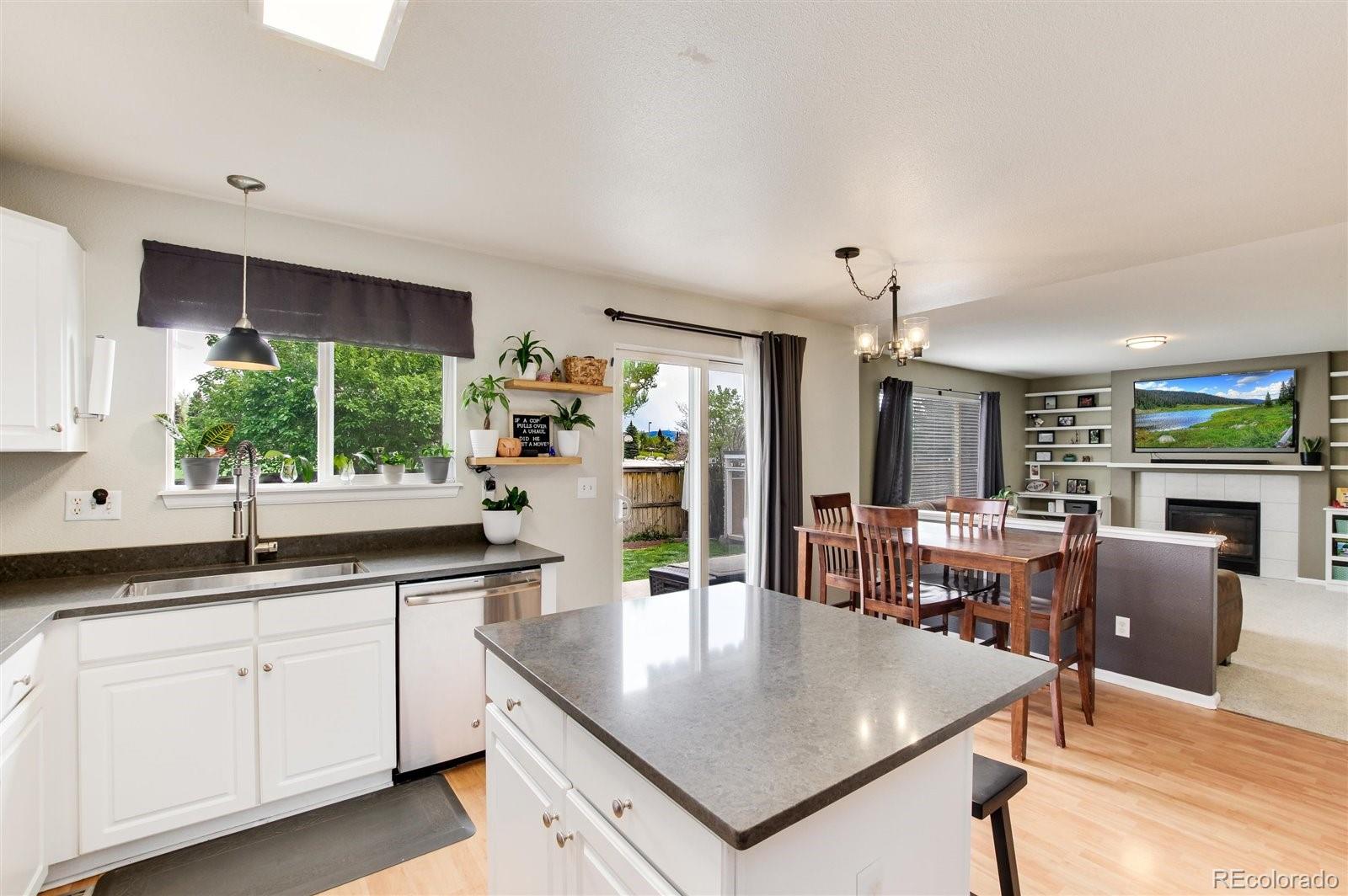 9701 Moss Rose Circle Highlands Ranch, CO 80129 - Photo 15 of 40 a kitchen with center island table and chairs in it