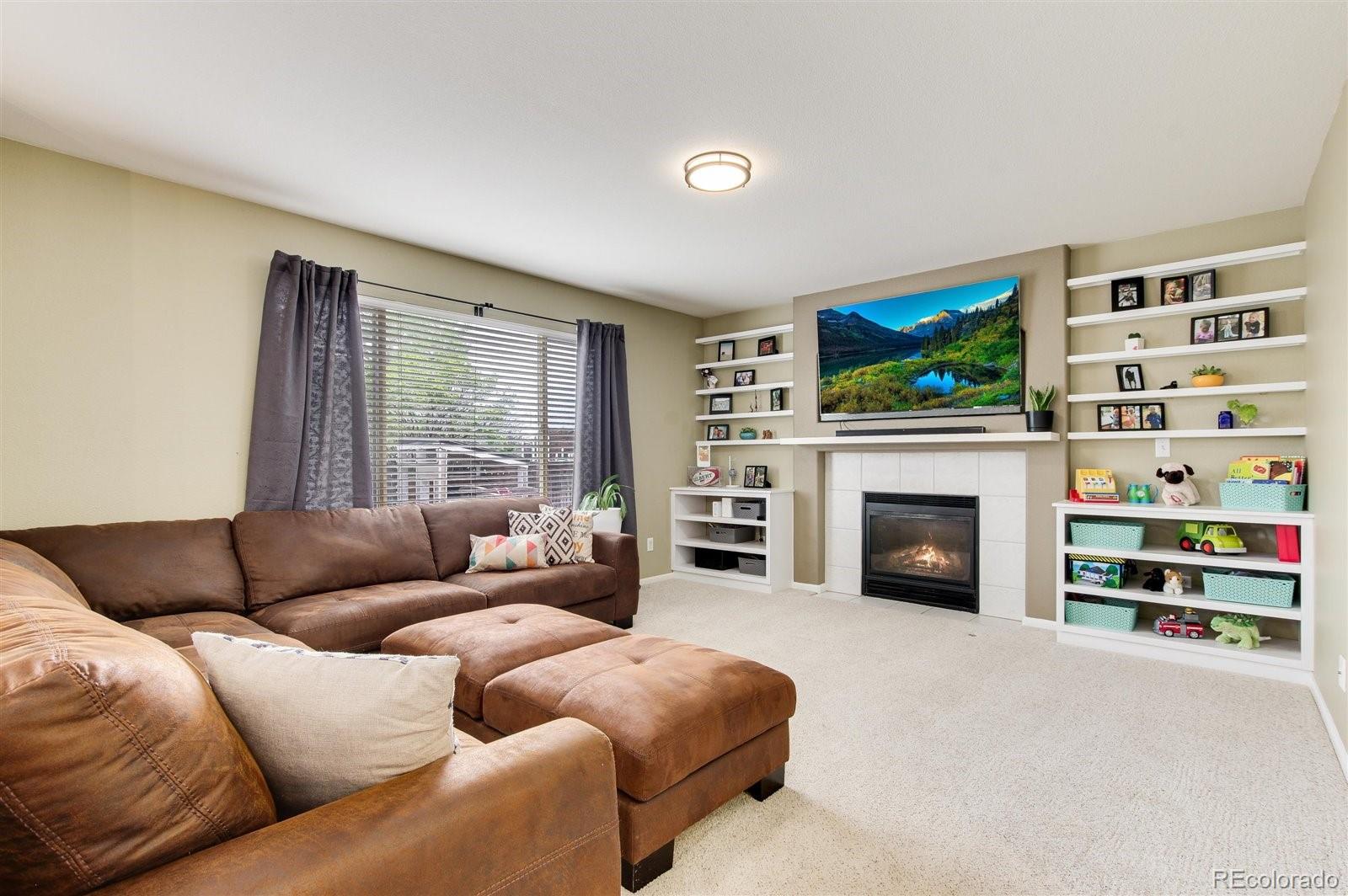 9701 Moss Rose Circle Highlands Ranch, CO 80129 - Photo 19 of 40 a living room with furniture a flat screen tv and a fireplace
