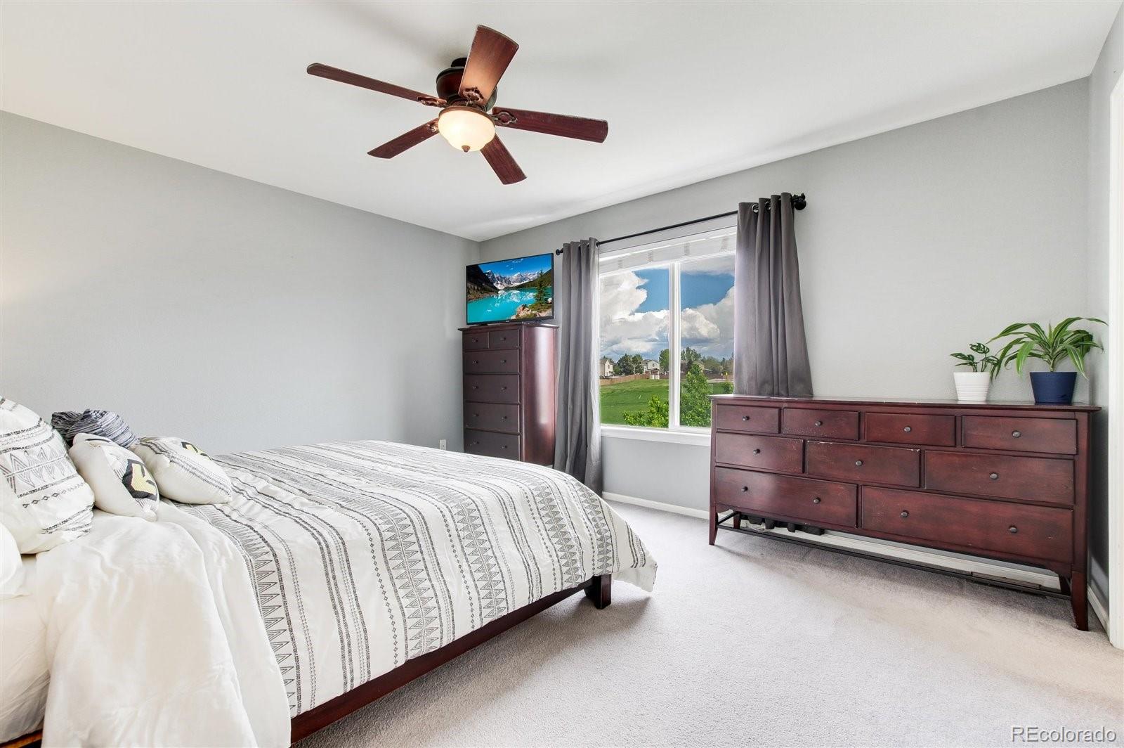 9701 Moss Rose Circle Highlands Ranch, CO 80129 - Photo 26 of 40 a bedroom with a bed dresser and a window