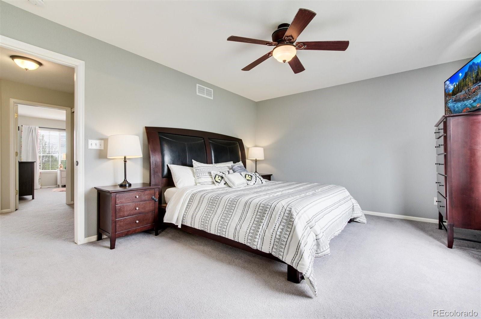 9701 Moss Rose Circle Highlands Ranch, CO 80129 - Photo 27 of 40 a bedroom with a bed and a ceiling fan