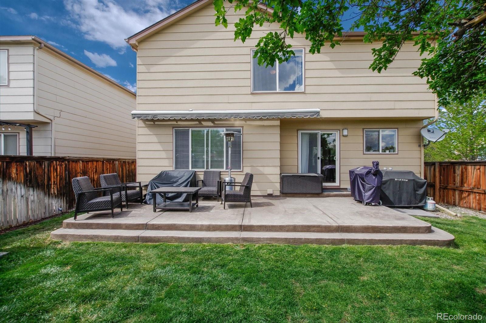 9701 Moss Rose Circle Highlands Ranch, CO 80129 - Photo 35 of 40 a view of a patio with table and chairs with wooden fence
