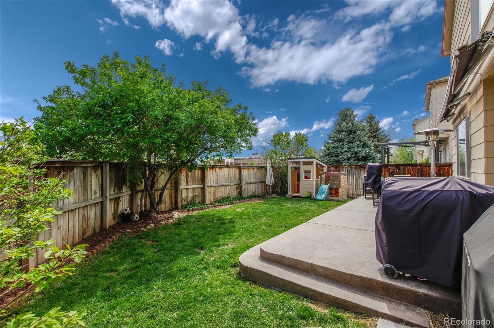 9701 Moss Rose Circle Highlands Ranch, CO 80129 - Photo 38 of 40 a view of a backyard with table and chairs and wooden fence