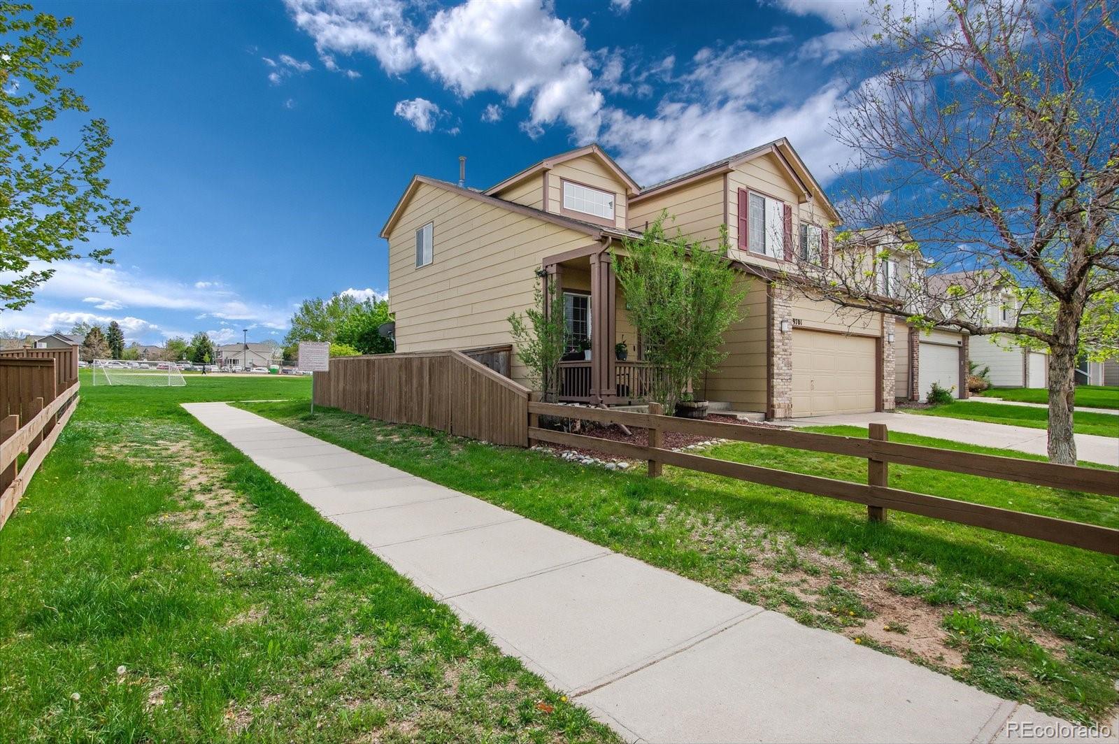9701 Moss Rose Circle Highlands Ranch, CO 80129 - Photo 5 of 40 a view of a house with a yard and a large tree