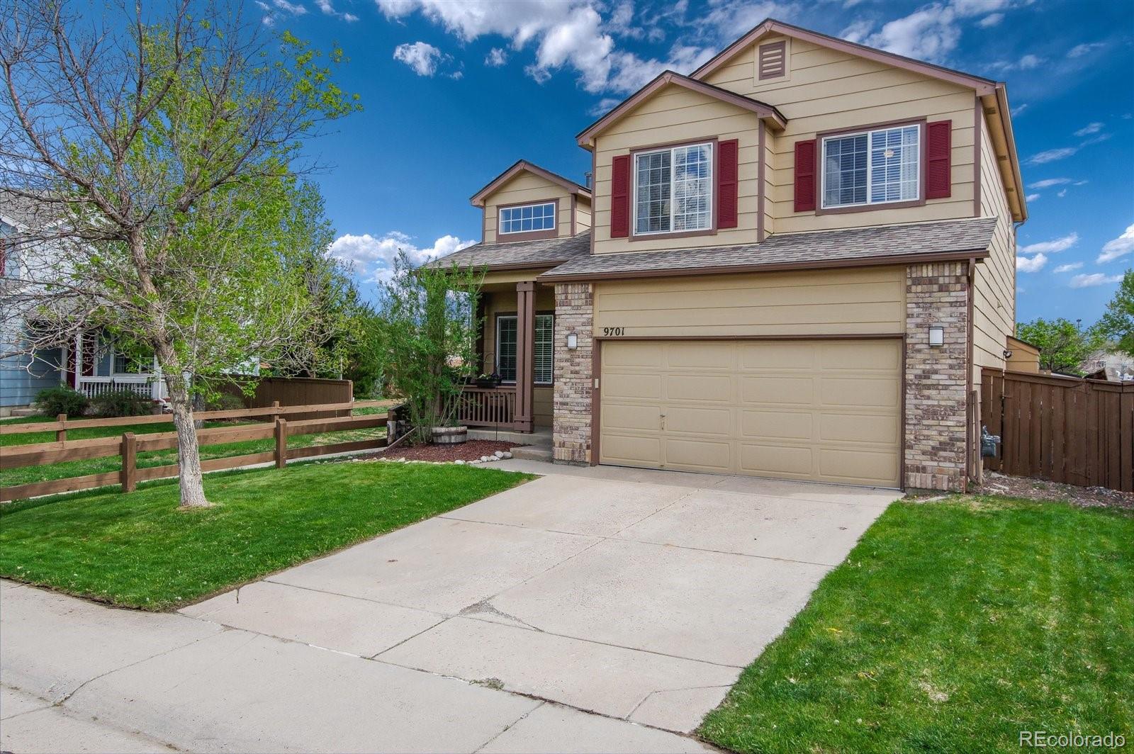 9701 Moss Rose Circle Highlands Ranch, CO 80129 - Photo 6 of 40 a front view of a house with a garden and garage