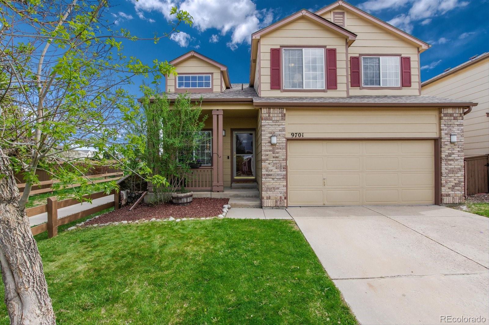 9701 Moss Rose Circle Highlands Ranch, CO 80129 - Photo 7 of 40 a front view of a house with a yard and garage