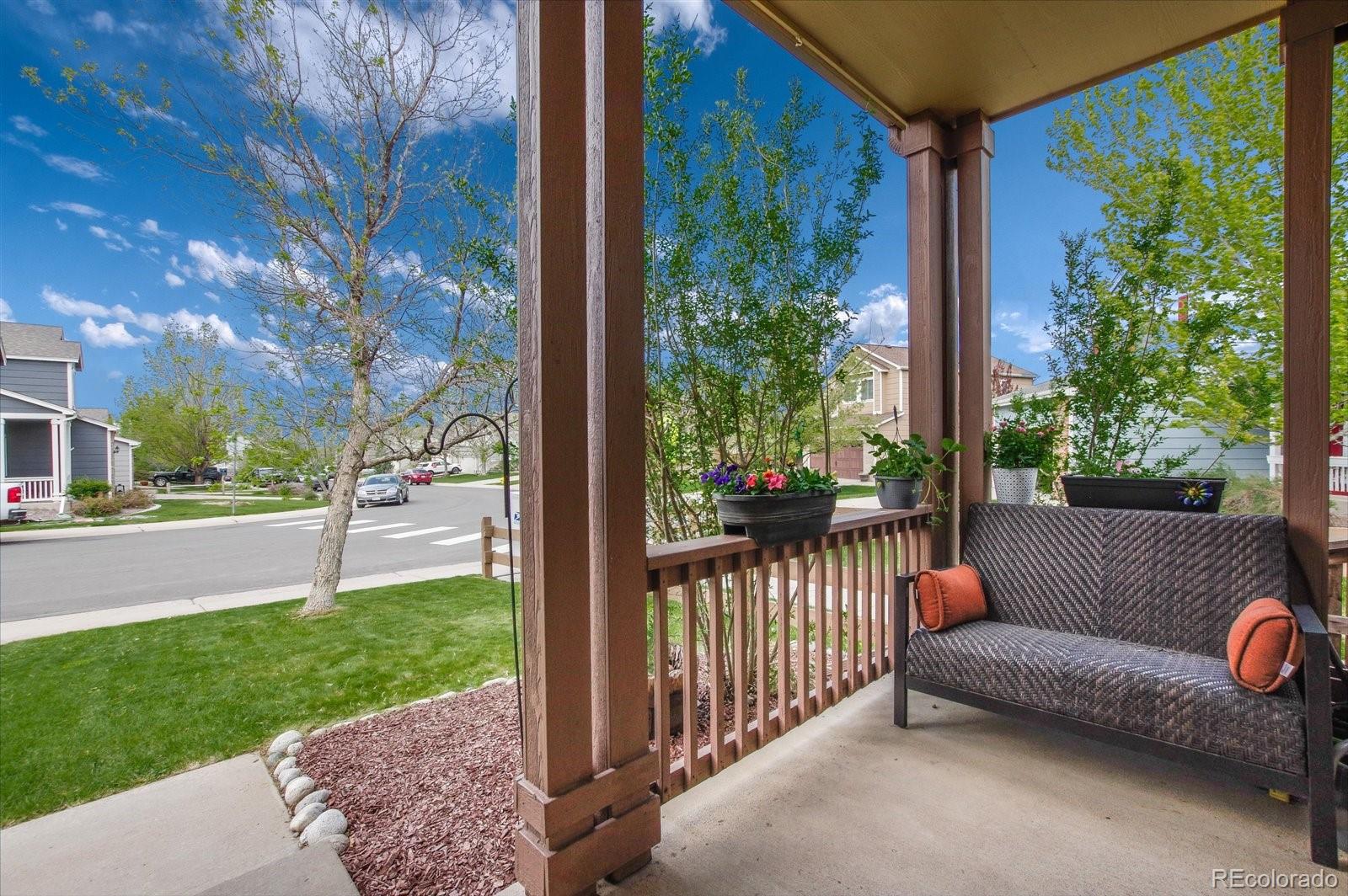 9701 Moss Rose Circle Highlands Ranch, CO 80129 - Photo 8 of 40 a view of a porch with couches and table and chairs next to yard