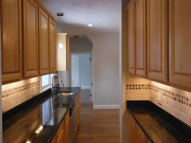 a kitchen with granite countertop a sink and a stove