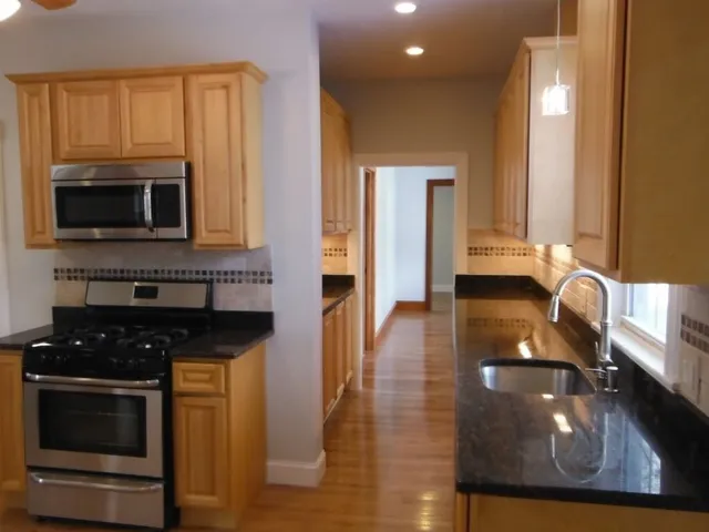 a kitchen with stainless steel appliances a stove a microwave a sink and cabinets