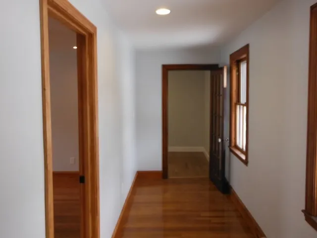 a view of a hallway with wooden floor and closet