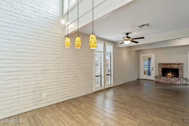 a view of an empty room with a fireplace and a window