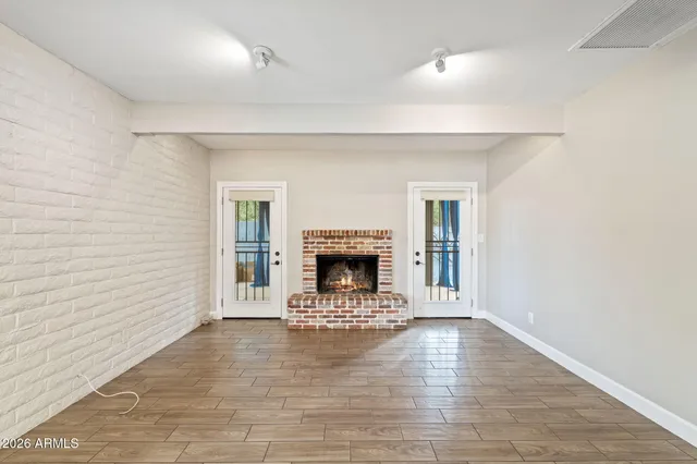 a view of an empty room with a fireplace and a window