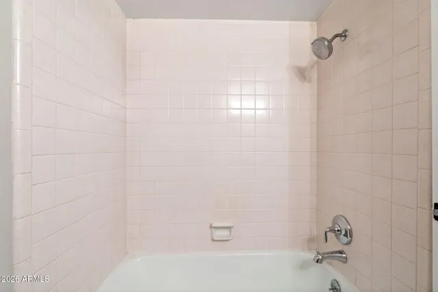 an empty room with a window and ceiling fan