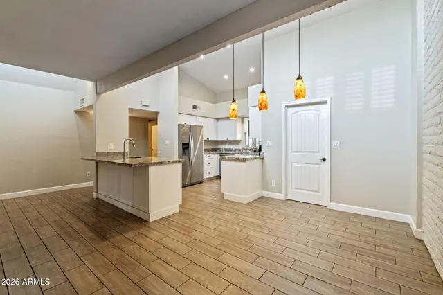 a kitchen with stainless steel appliances a refrigerator and white cabinets