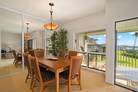 a dining room with furniture a chandelier and wooden floor