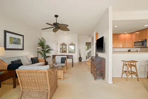 a living room with furniture a flat screen tv and kitchen view