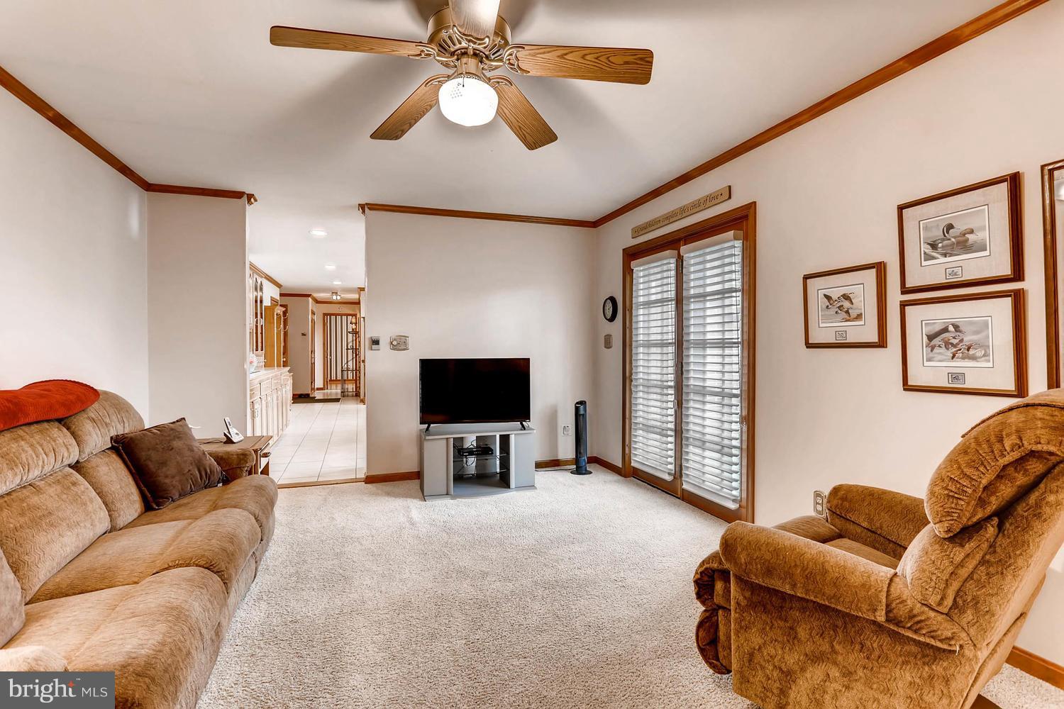 14000 Baldwin Mill Road Baldwin, MD 21013 - Photo 14 of 28 a living room with furniture a ceiling fan and a flat screen tv