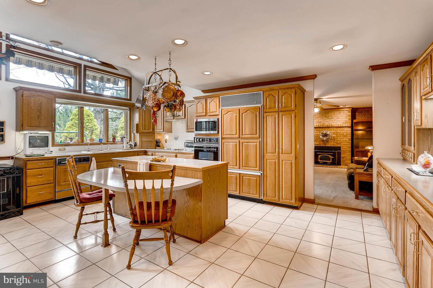14000 Baldwin Mill Road Baldwin, MD 21013 - Photo 8 of 28 a kitchen with stainless steel appliances granite countertop a stove a refrigerator a dining table and chairs with wooden floor